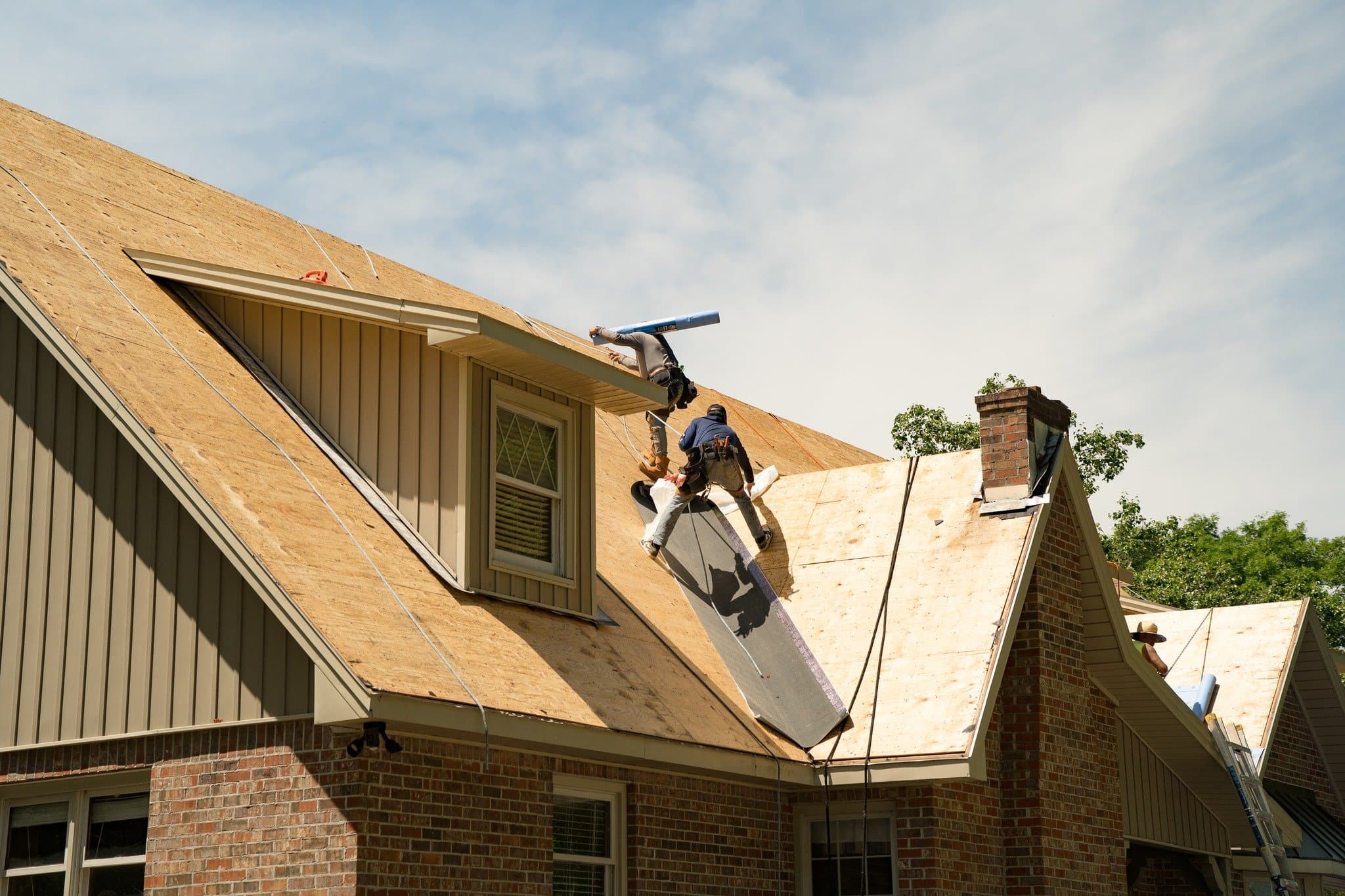 Evergreen Roofing crew laying underlayment on a residential roof
